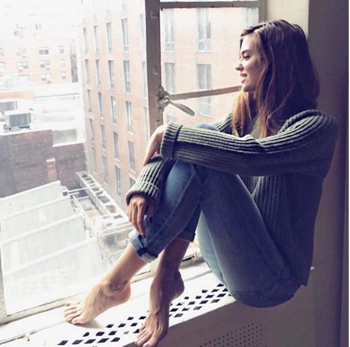 Clara Alonso looking to city from the window.